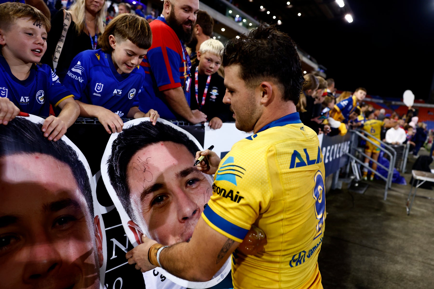 Supporters holding Sports Heads at a live game